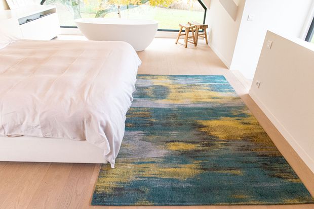 blue and yellow rug in a bedroom